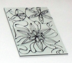 Black and white photograph of a geometric flower and swirled accents on glass