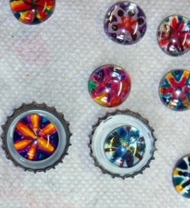 Clear glass cabachon gems with brightly colored flowers painted on the back.